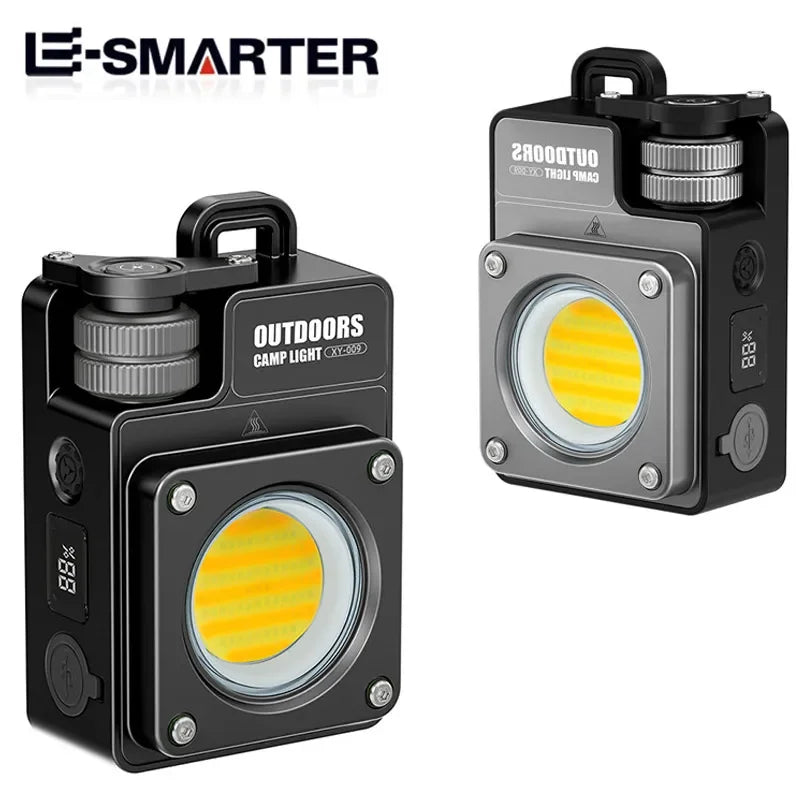 Two views of a black and gray E-SMARTER outdoor COB camp light on a white background, showing the front with the illuminated yellow COB LED lens and the side with the digital display.